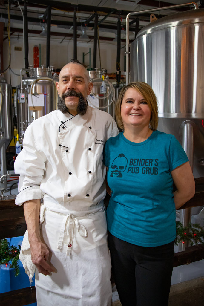 Lora Damron and Chef Shawn Weinbender standing inside of Alexandria Brewing Company.