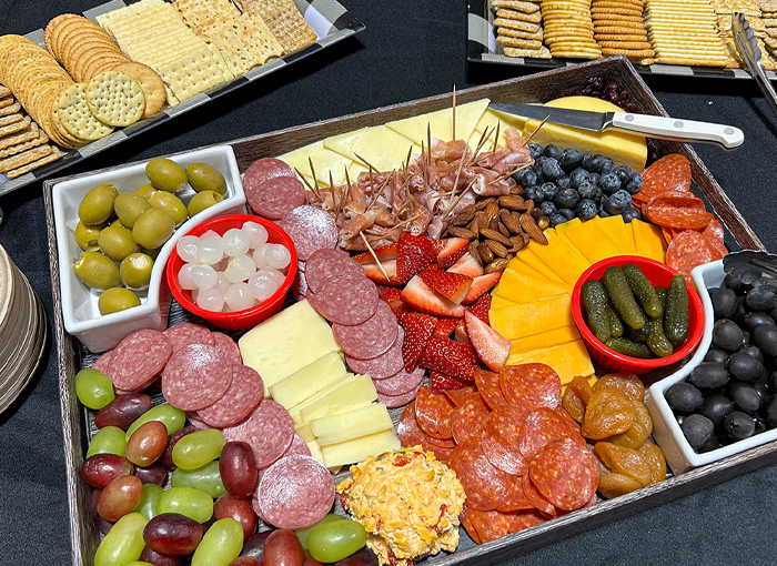 A photo of a charcuterie board with assorted meats, cheeses, fruits, and nuts.